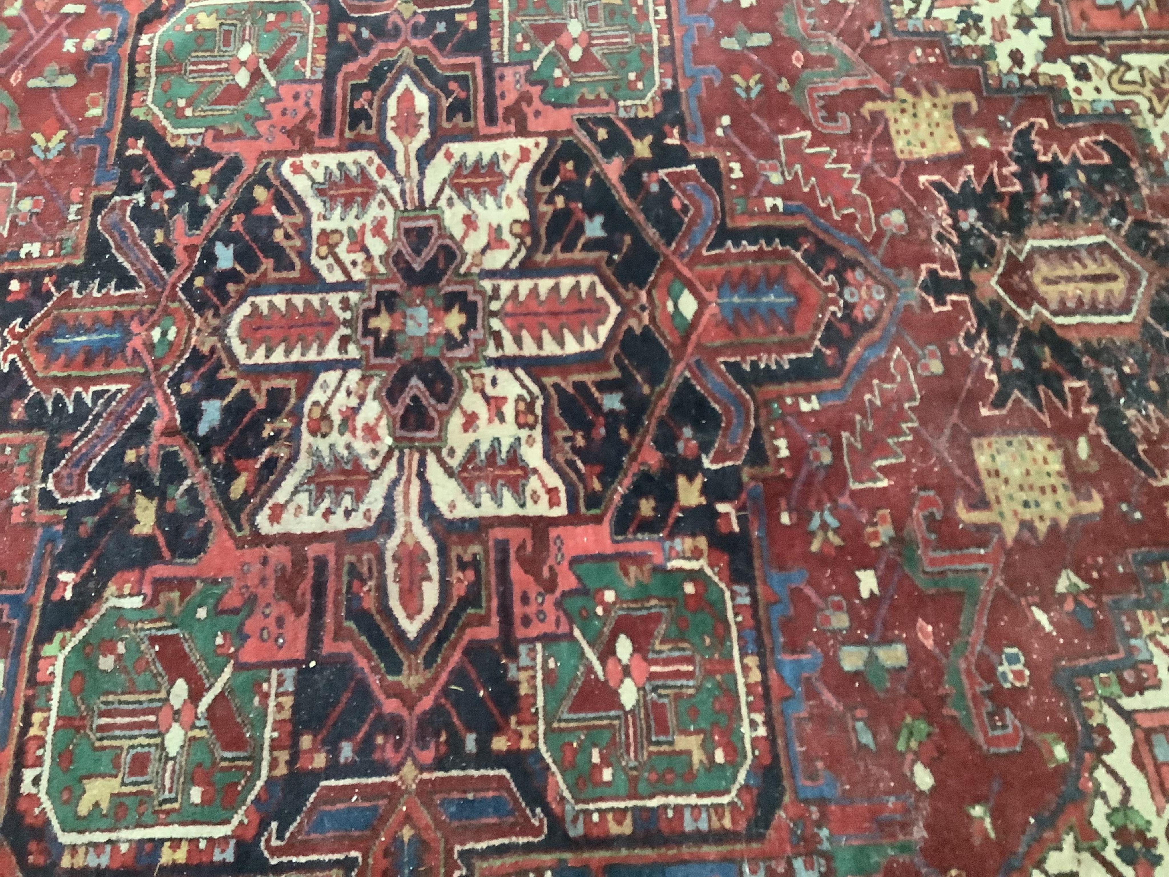 A Heriz red ground carpet, 340 x 267cm. Condition - poor to fair